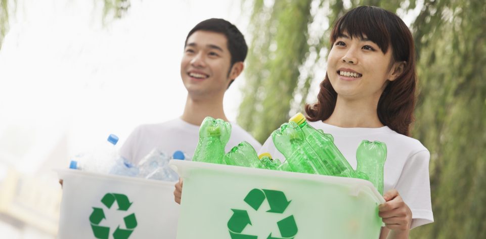 Two Young People Recycling Plastic Bottles
